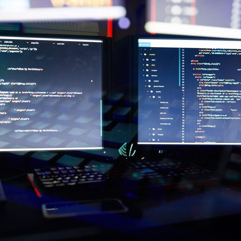 Two computer monitors installing software in a dark office